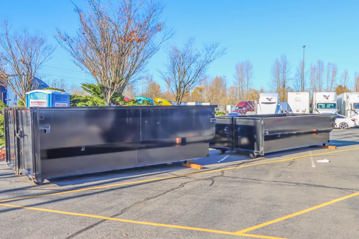 Professional dumpster rental service with roll-off container on residential driveway in Red Hill